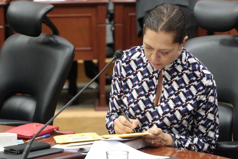 Adriana Favela Herrera, Consejera Electoral firmando sobre con muestras.
