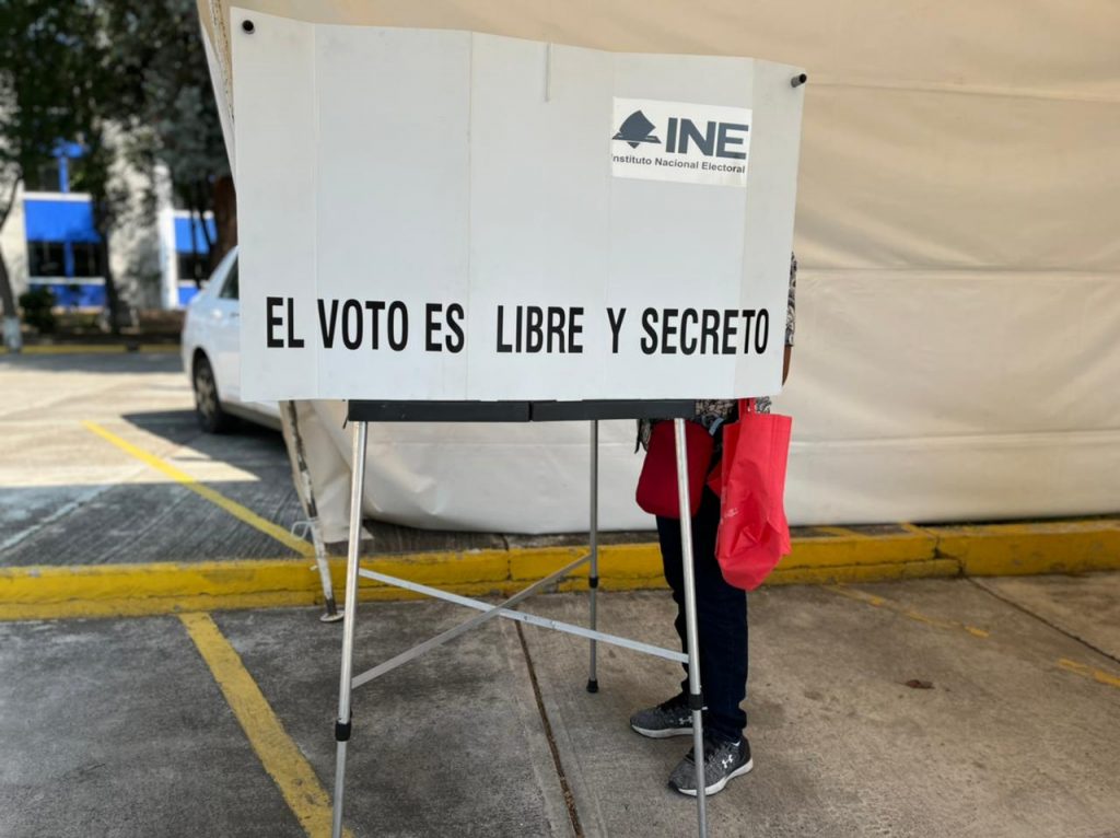 Persona ejerciendo su voto en un panel de votación