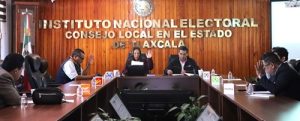 Integrantes del Consejo Local del INE Tlaxcala votando, con la mano derecha alzada, para la destrucción de las credenciales para votar