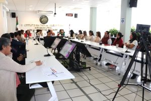 varias personas sentadas en salón de sesiones del consejo local