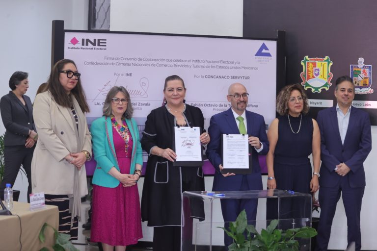 Participantes de la Firma de pie con el documento en las manos.
