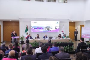 Personas participantes sentados en el estrado frente al público asistente y la Consejera Presidente en el podio.
