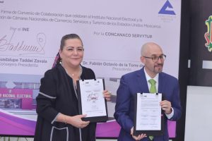 Guadalupe Taddei Consejera Presidenta y Fabián Octavio de la Torre Presidente de la CONCANACO-SERVYTUR de pie con el documento en las manos.