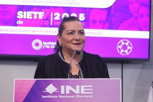 Consejera Presidenta, Guadalupe Taddei Zavala hablando en el pódium al frente del recinto.