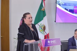 Guadalupe Taddei Consejera Presidenta parada en el pódium al público asistente.