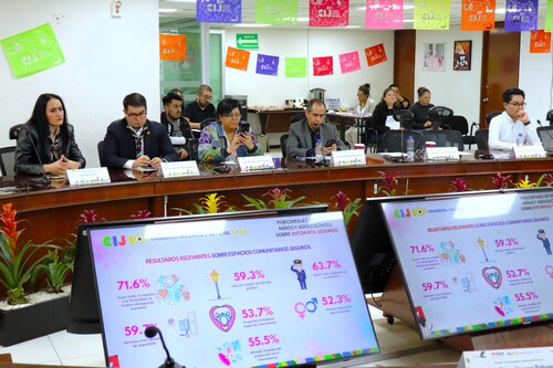 cuatro personas sentadas a un costado de la mesa de sesiones