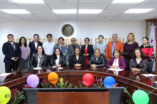 diecisiete personas de pie y agrupadas para tomarse fotografía oficial de la reunión de trabajo