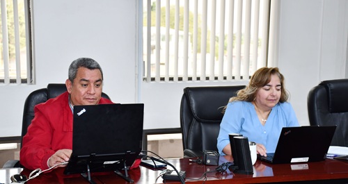 Dos personas sentadas enfrente de sus computadoras en la capacitación