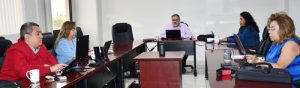 cinco personas sentadas enfrente de computadoras tomando la capacitación