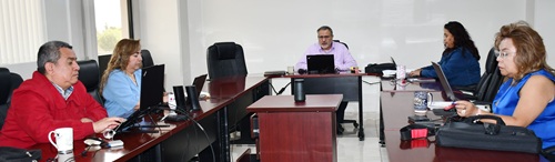 cinco personas sentadas enfrente de computadoras tomando la capacitación 
