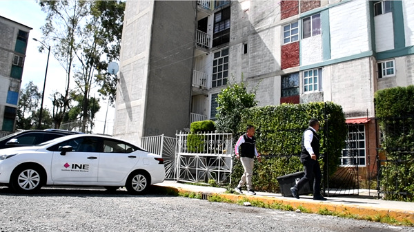 Funcionarios del INE caminando hacia un domicilio para atender a una persona 