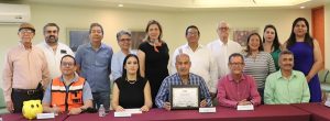 Varias personas unas de pie y otras sentadas mostrando un reconocimiento