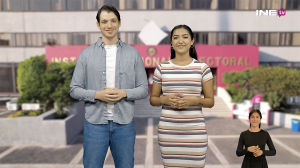 Muchacho y muchacha parados uno al lado de la otra con el edificio del INE al fondo