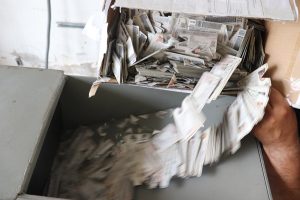 varias credenciales para votar cayendo al interior de una trituradora para ser destruidas