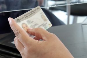 Se muestra una mano sosteniendo una credencial para votar