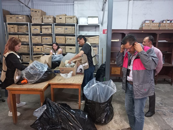 seis trabajadores del INE poniendo en bolsas de plástico la pedacería de las credenciales