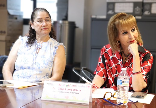 dos personas mujeres sentadas y observando al orador de la reunión