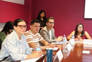 cuatro personas sentadas y observando al orador de la reunión