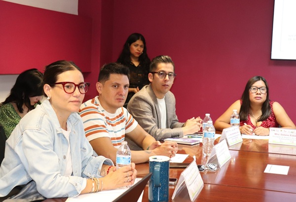 cuatro personas sentadas y observando al orador de la reunión
