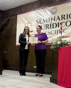 Mujer entregando reconocimiento a otra mujer