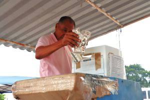 Una persona metiendo credenciales para votar destruidas en una caja blanca