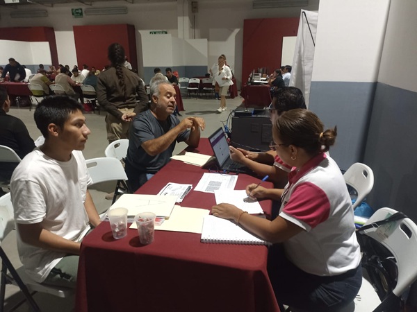 Trabajadora del INE platica con dos personas repatriadas sobre cómo tener su credencial para votar