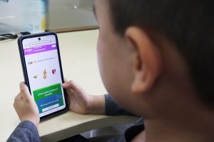 niño con celular en las manos contestando la Consulta Infantil 2024