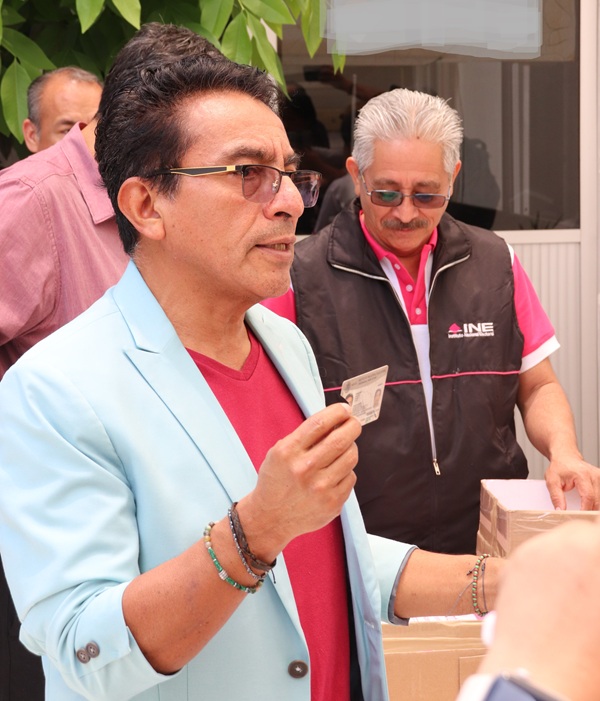 hombre sosteniendo una credencial para votar