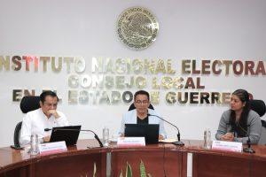 personas sentadas atrás de una mesa con micrófonos