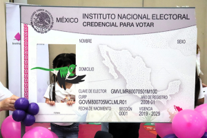 Niña tomándose una foto en el simulador de credencial para votar gigante