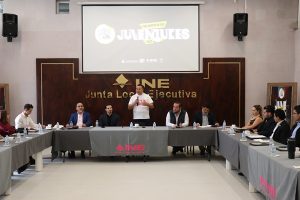 personas jóvenes sentados en alrededor de una mesa rectangular