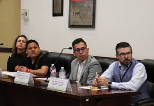 personas representantes de los partidos sentados viendo a la derecha