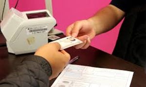 una persona entregando una credencial para votar