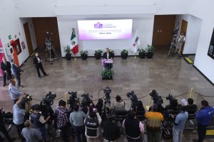 Imagen del lobby con la Consejera Presidenta Guadalupe Taddei Zavala de pie parada en pódium.