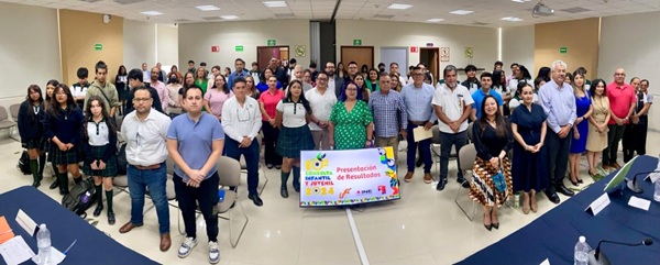 muchas personas de pie en un salón frente a una lona de la Consulta Infantil 2024