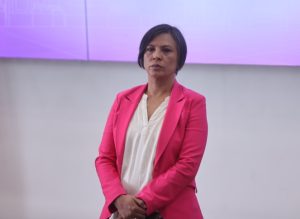 Norma Irene De La Cruz Magaña Consejera Electoral parada frente al público asistente.