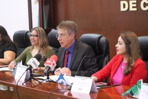 un hombre sentado frente a varios micrófonos