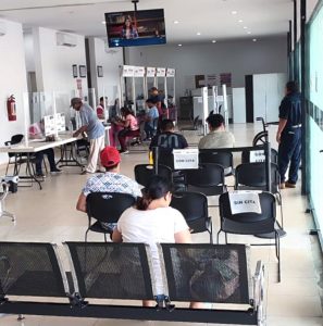 interior de un módulo del INE con personas sentada en sala de espera