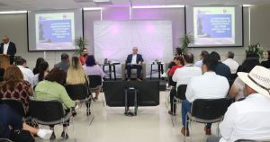 hombre sentado frente a muchas personas en un salón