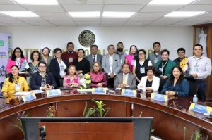 personas sentada alrededor de una mesa con micrófonos