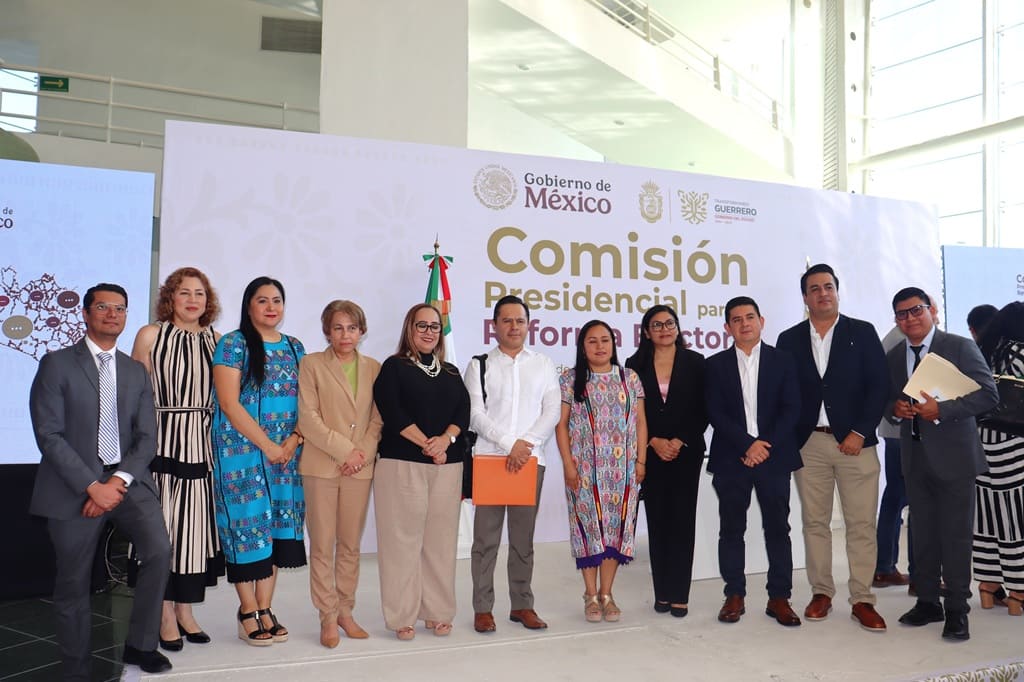 mujeres y hombres de pie sobre un escenario posando para la foto