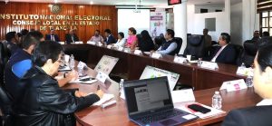 varias personas sentadas alrededor de una mesa con micrófonos