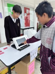 adolescentes hombres con uniforme de secundaria votando en maquina