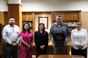 cinco personas de pie en una oficina de color madera