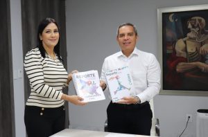 una mujer y un hombre ambos de pie mostrando unos documentos