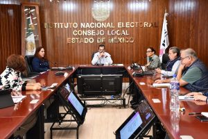 varias personas sentadas alrededor de una mesa color café con micrófonos