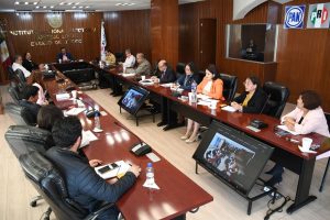 varias personas sentadas alrededor de una mesa rectangular de madera