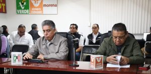 personas sentadas frente a una mesa con micrófono