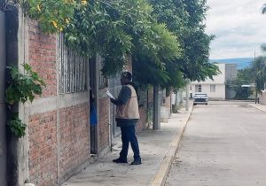 hombre con chaleco afuera de una casa