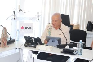 adulto mayor sentado frente a una computadora